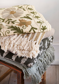 recycled cotton throw in off white and mustard stripes stacked with artisan blankets
