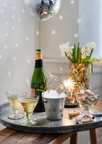 hammered glass ice cups styled on a table with drinks and desserts
