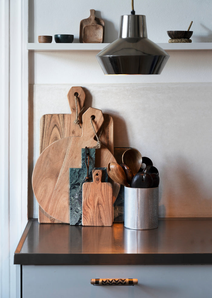 tiny wooden trays on a kitchen shelf with other rustic boards and utensils
