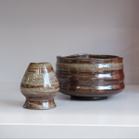 bark glazed ceramic chasen naoshi matcha whisk stand beside matching matcha bowl
