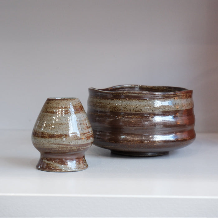 bark glazed ceramic chasen naoshi matcha whisk stand beside matching matcha bowl
