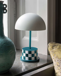 teal and white checkered portable Riviera lamp styled on a windowsill
