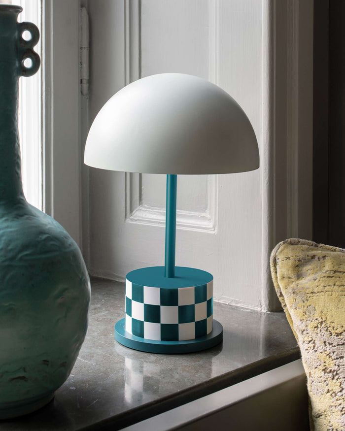 teal and white checkered portable Riviera lamp styled on a windowsill
