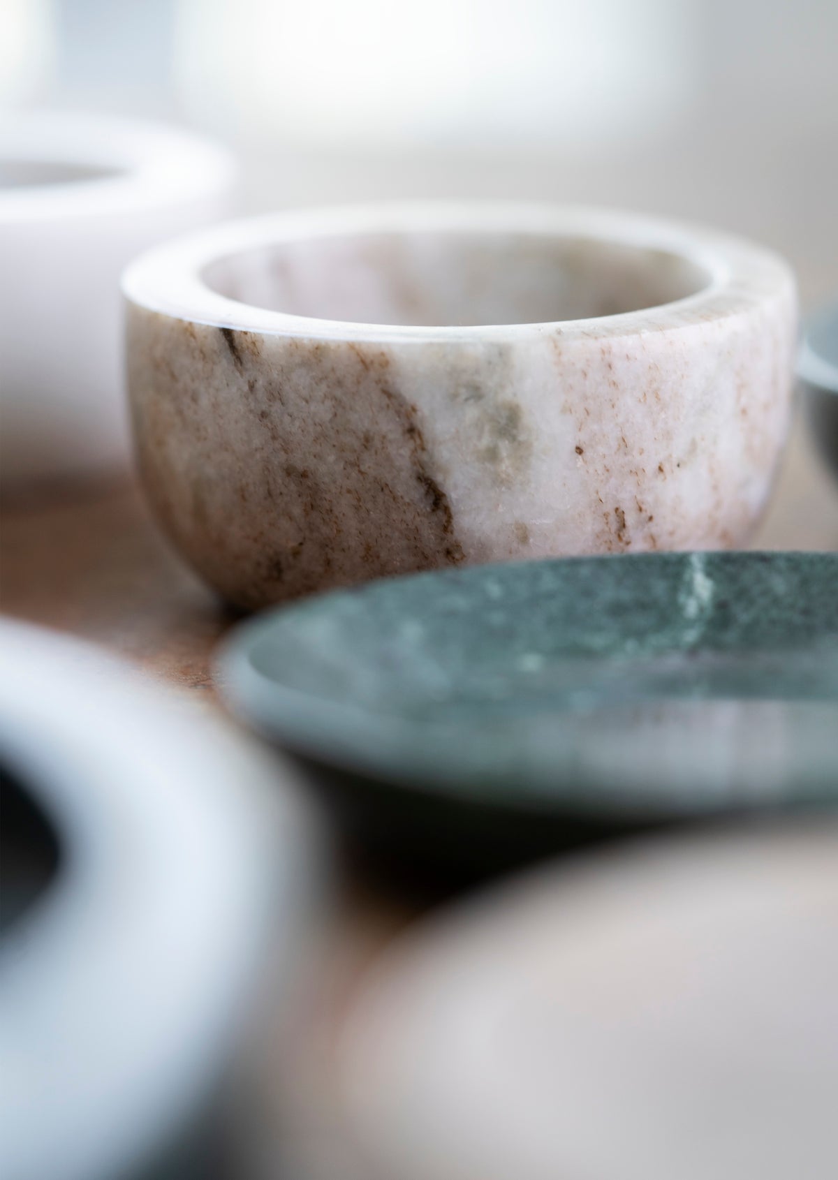 close up of hand-carved beige marble bowl showing natural veining and smooth rounded edges