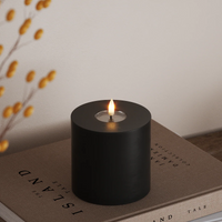 short wide black LED candle with realistic flame styled on coffee table for cosy evenings