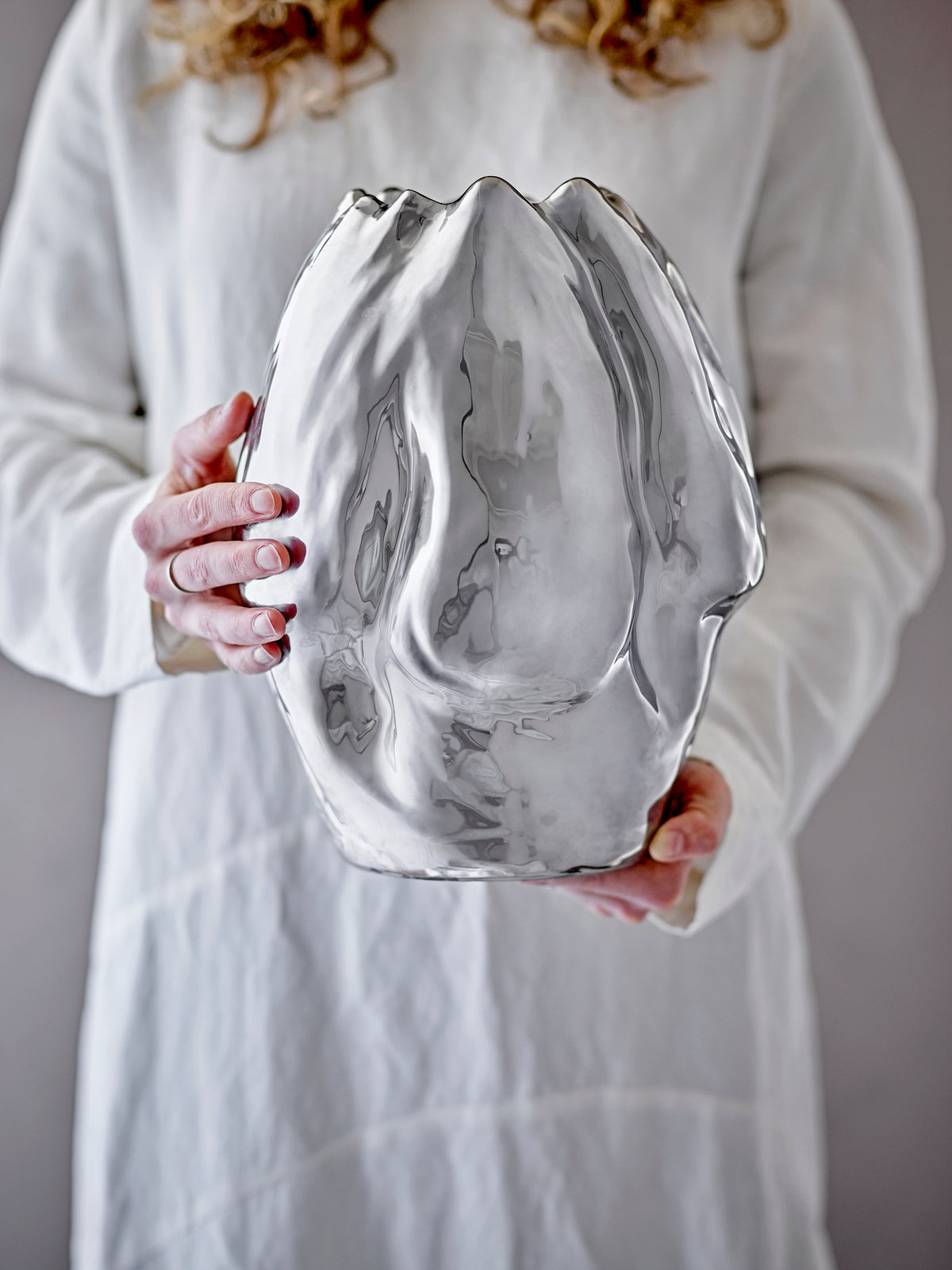 large reflective silver bobby vase by bloomingville held in hands showing organic shape