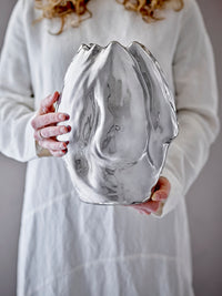 large reflective silver bobby vase by bloomingville held in hands showing organic shape