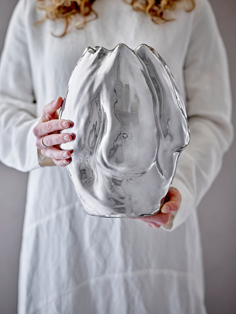 large reflective silver bobby vase by bloomingville held in hands showing organic shape