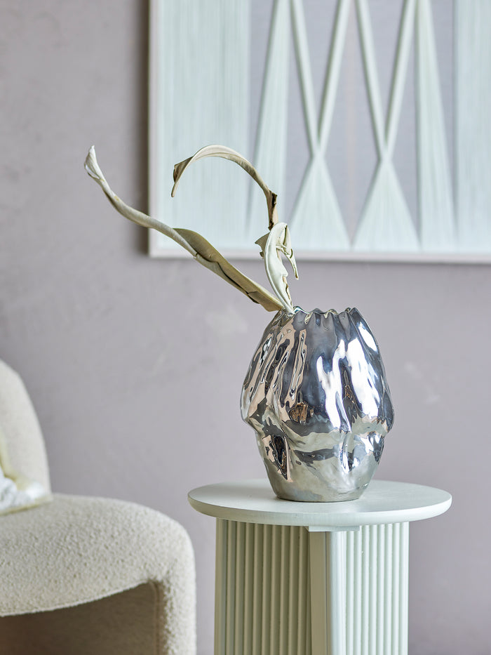 silver sculptural bobby vase by bloomingville styled on side table in modern home