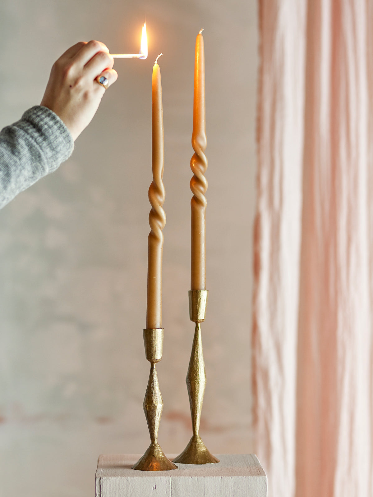 hand lighting brown bloomigville twist candles for a cosy warm ambience
