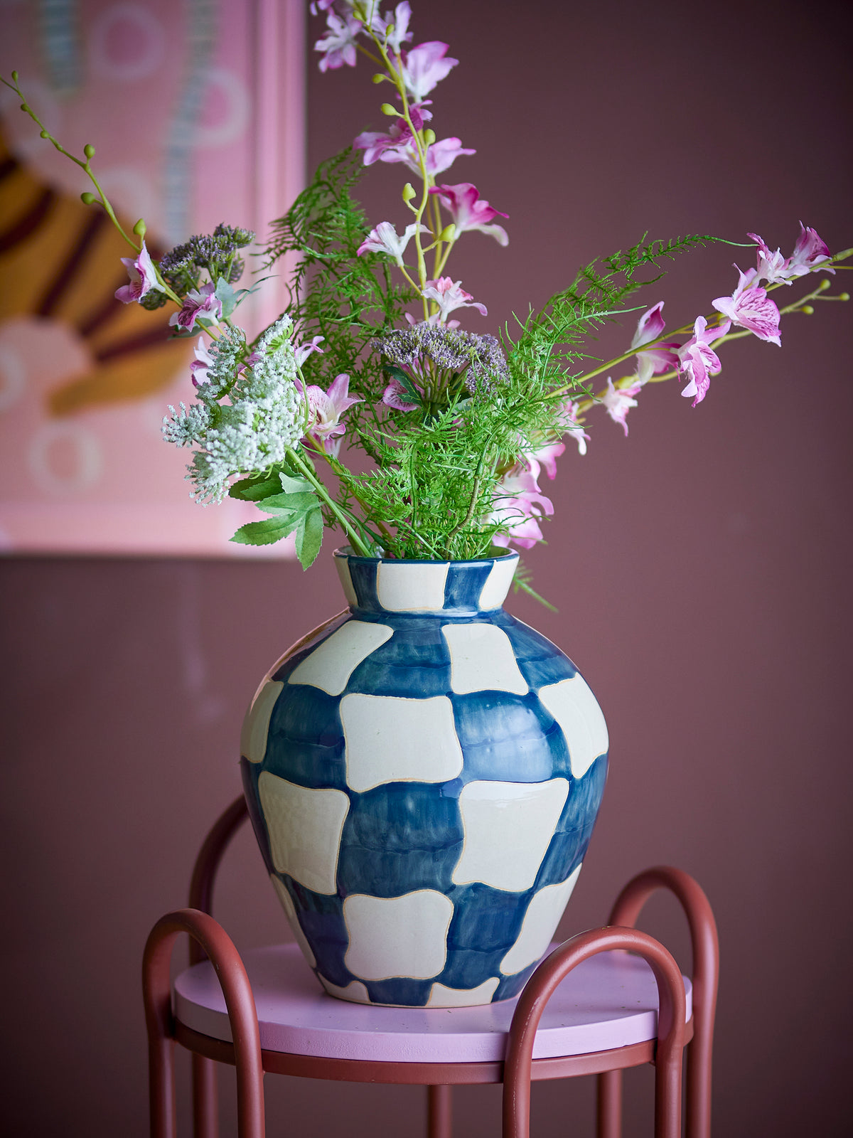 blue and cream checkered bloom­ingville stoneware vase styled with flowers on pink stand