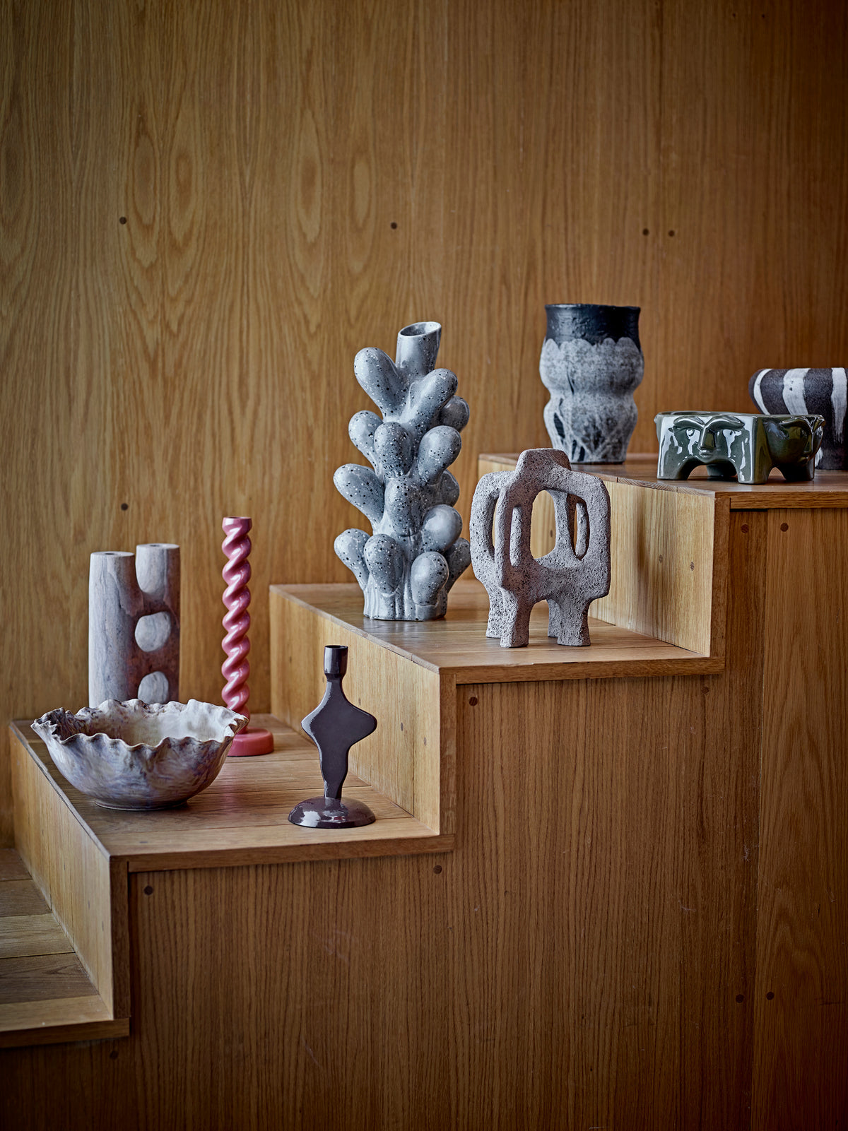 warm brown spiral candle holder by bloomindgville styled on wooden steps with ceramics
