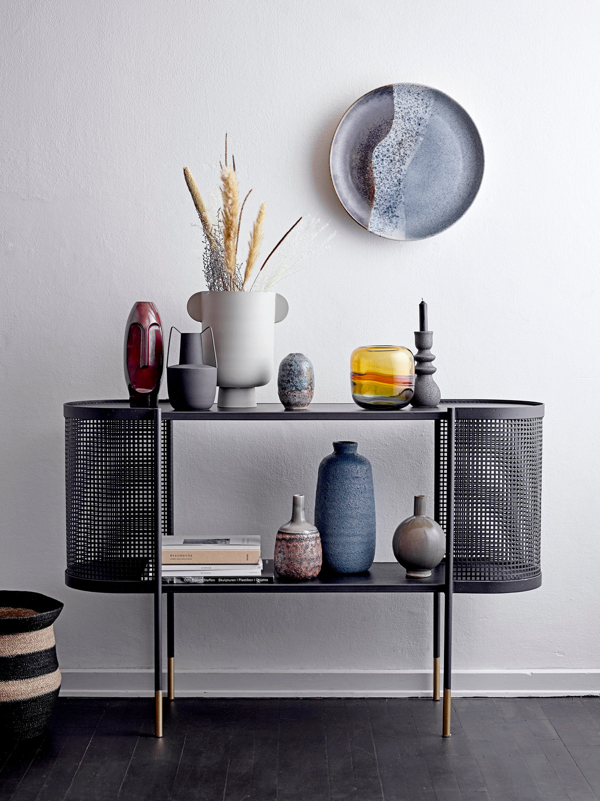 sculptural black candle holder displayed with Nordic ceramics on black console