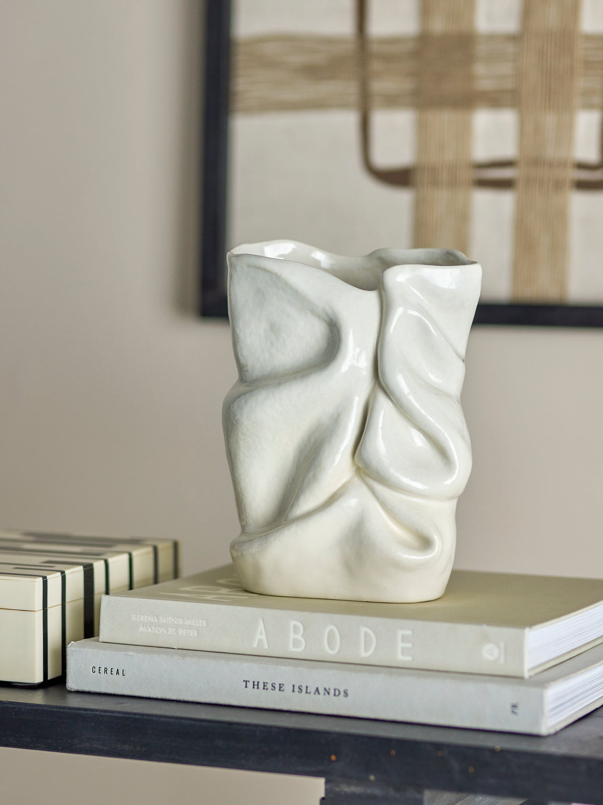 sculptural white bloomingville fabrice vase styled on books in a modern neutral living space