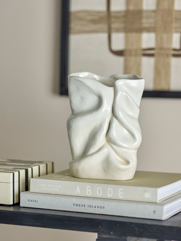 sculptural white bloomingville fabrice vase styled on books in a modern neutral living space