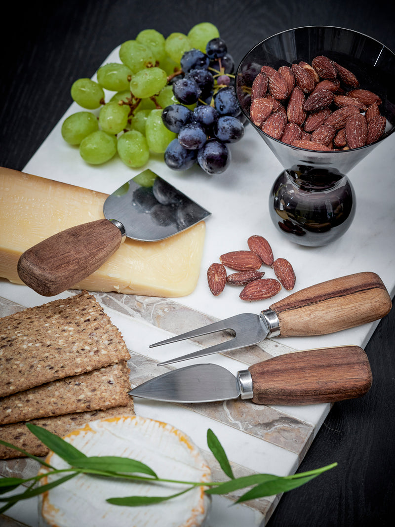 cheese board with bloomingville lisamai acacia cheese knives styled with grapes crackers and almonds
