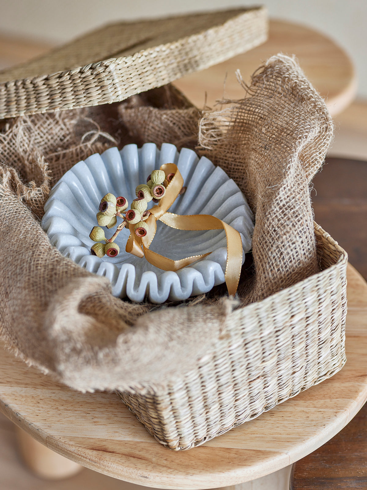 White marble bowl detail showing Rajasthan-inspired carving technique in a wicker basket