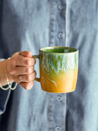 person holding green bloomingville milani mug showing handcrafted reactive glaze
