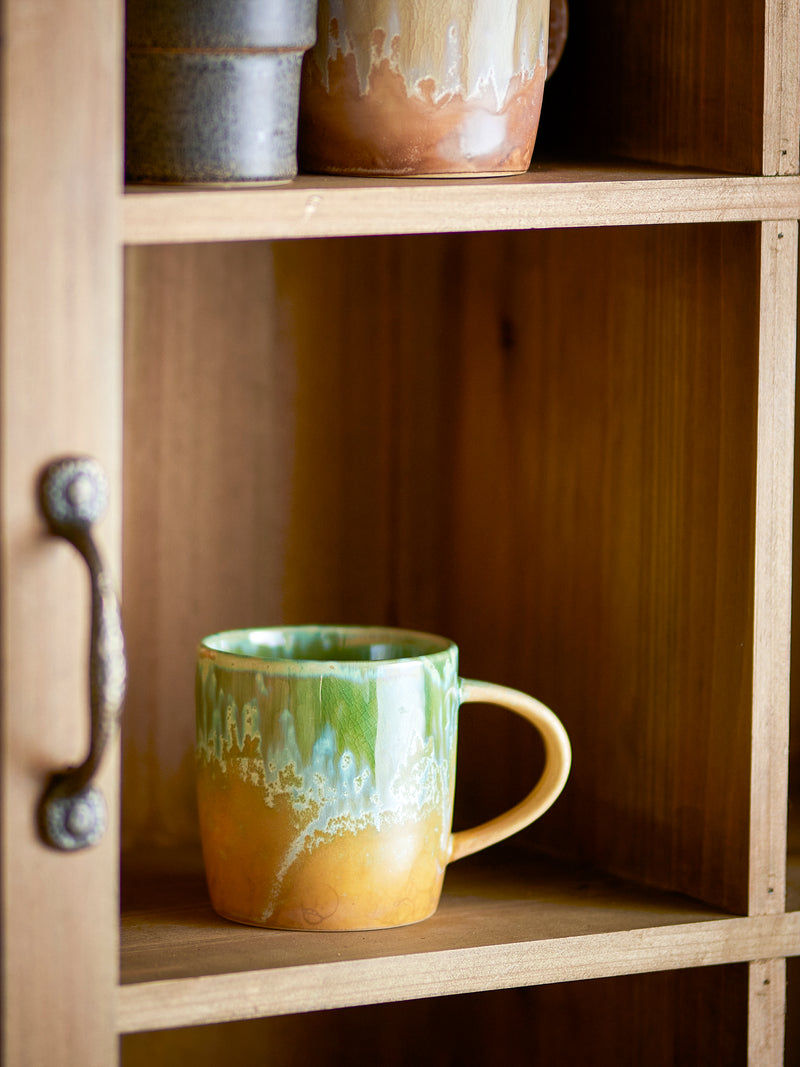 green bloomingville milani mug styled on rustic wooden shelving with reactive glaze detail
