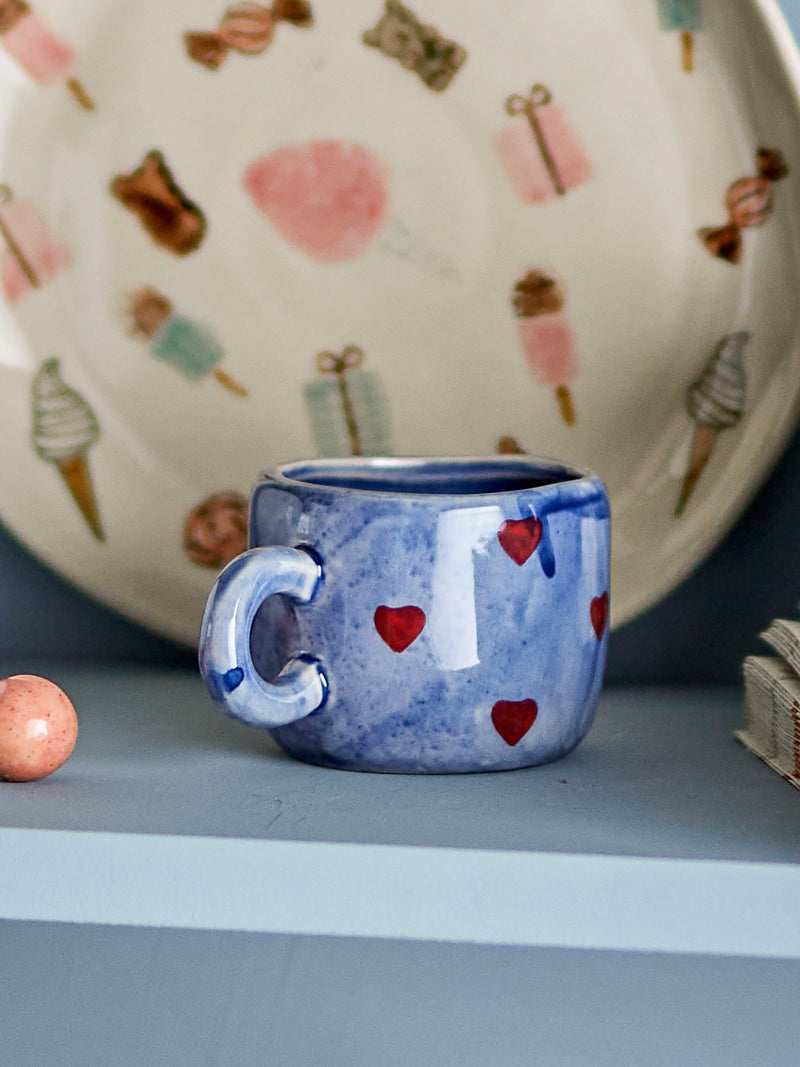 blue bloomingville nini cup with red hearts styled on a kitchen shelf