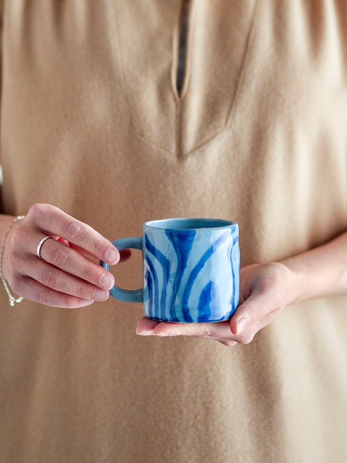 person holding blue bloomingville ninka mug showing hand-decorated glaze pattern