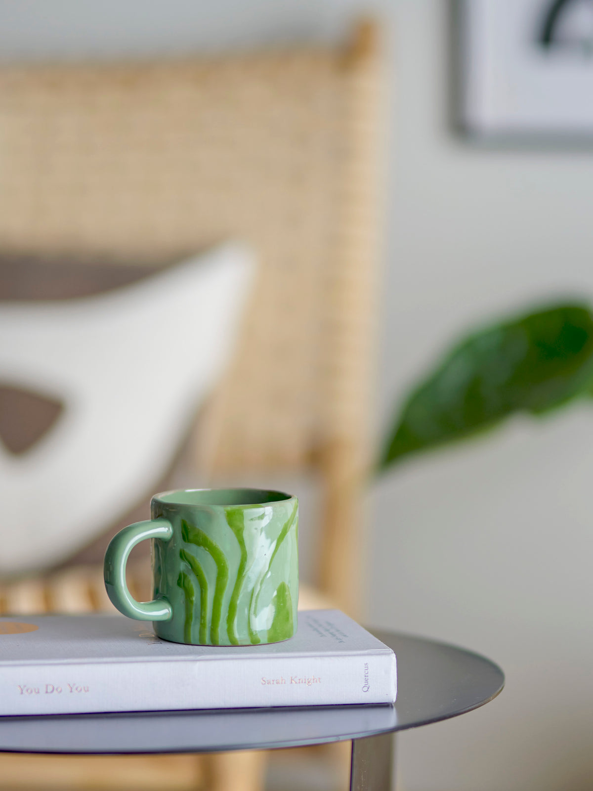 green bloomingville ninka mug styled on a book for a calm cosy living room moment

