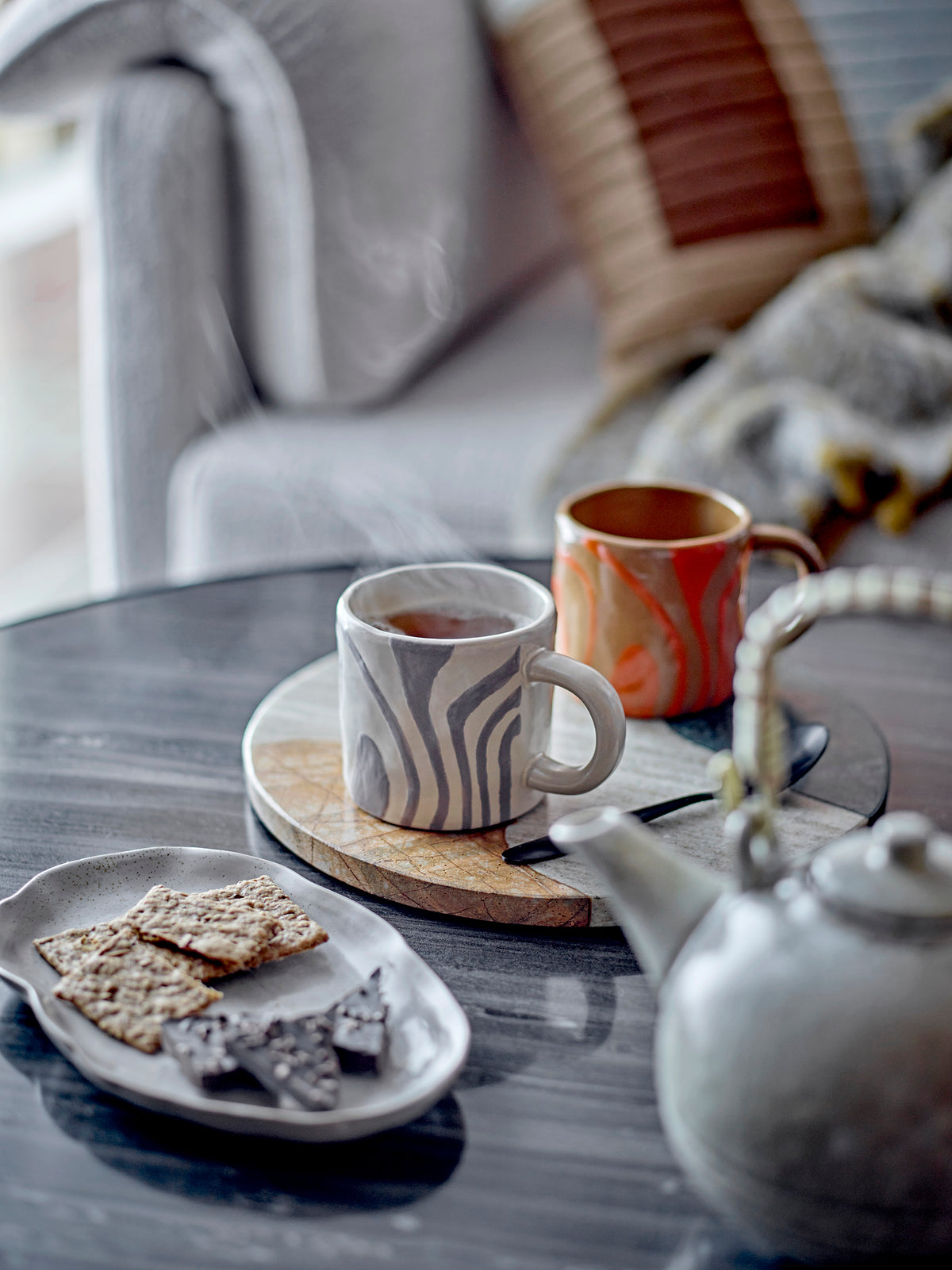 orange and grey bloomingville ninka mugs on a coffee table creating a cosy tea moment
