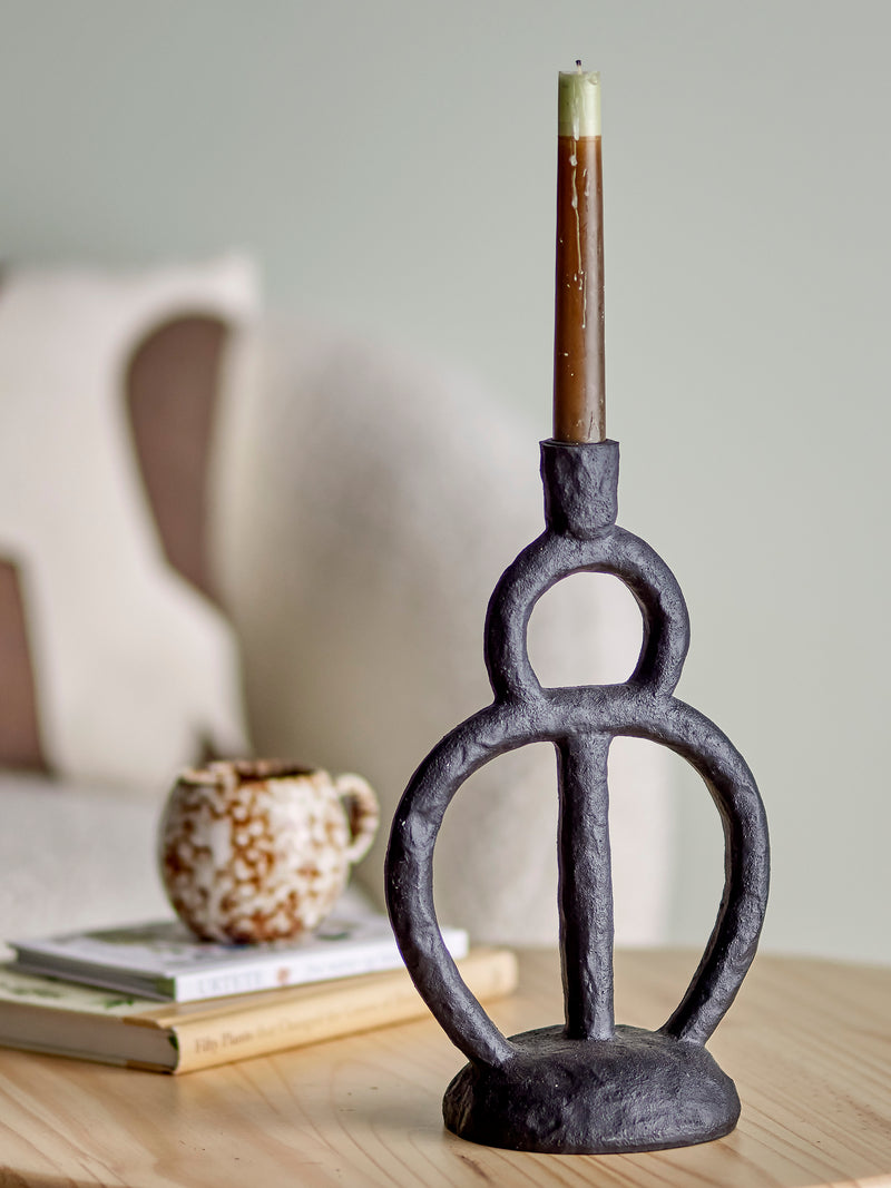 close up of ramina candle holder in black polyresin on table with lit candle
