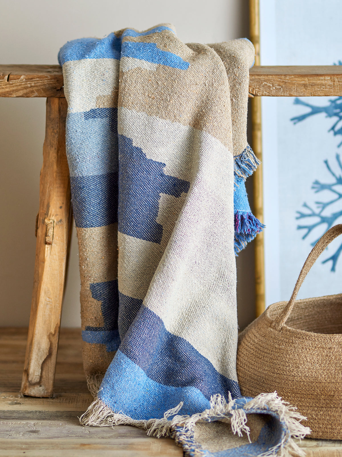 Blue recycled cotton throw draped on wooden furniture