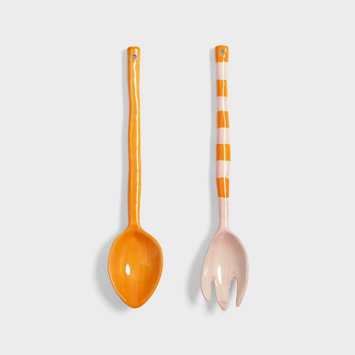 Product shot of two colourful porcelain salad utensils side by side.