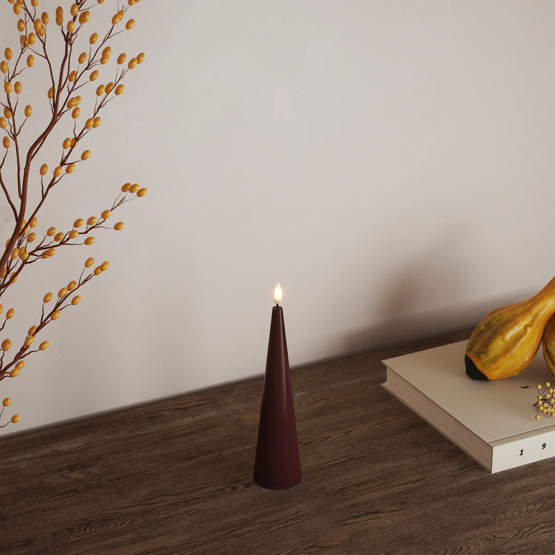 tall burgundy led cone candle adding warm mood lighting to interior
