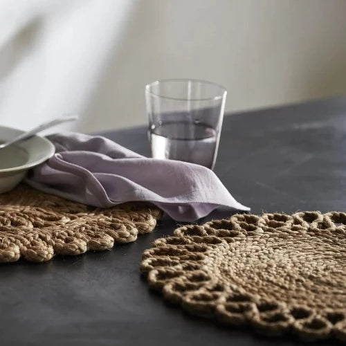 hemp placemats set apon a marble table with someone set with a bowl of breakfast and a glass of water