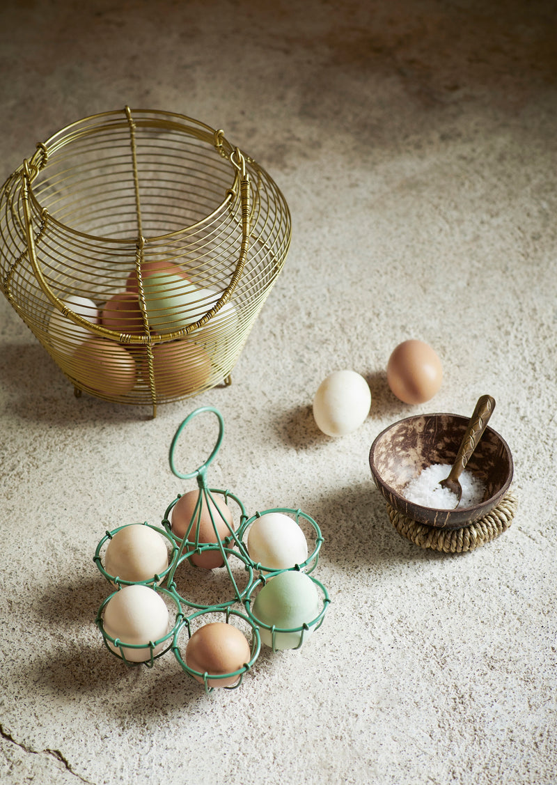 Brass spoon in a coconut bowl filled with salt beside vintage kitchen accessories