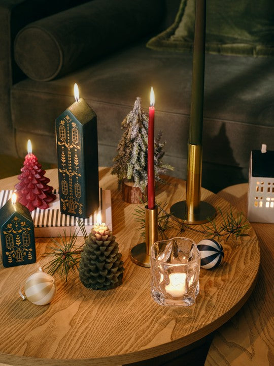 Brass Maro candle holders with red and green tapers on a festive coffee table with house-shaped candles