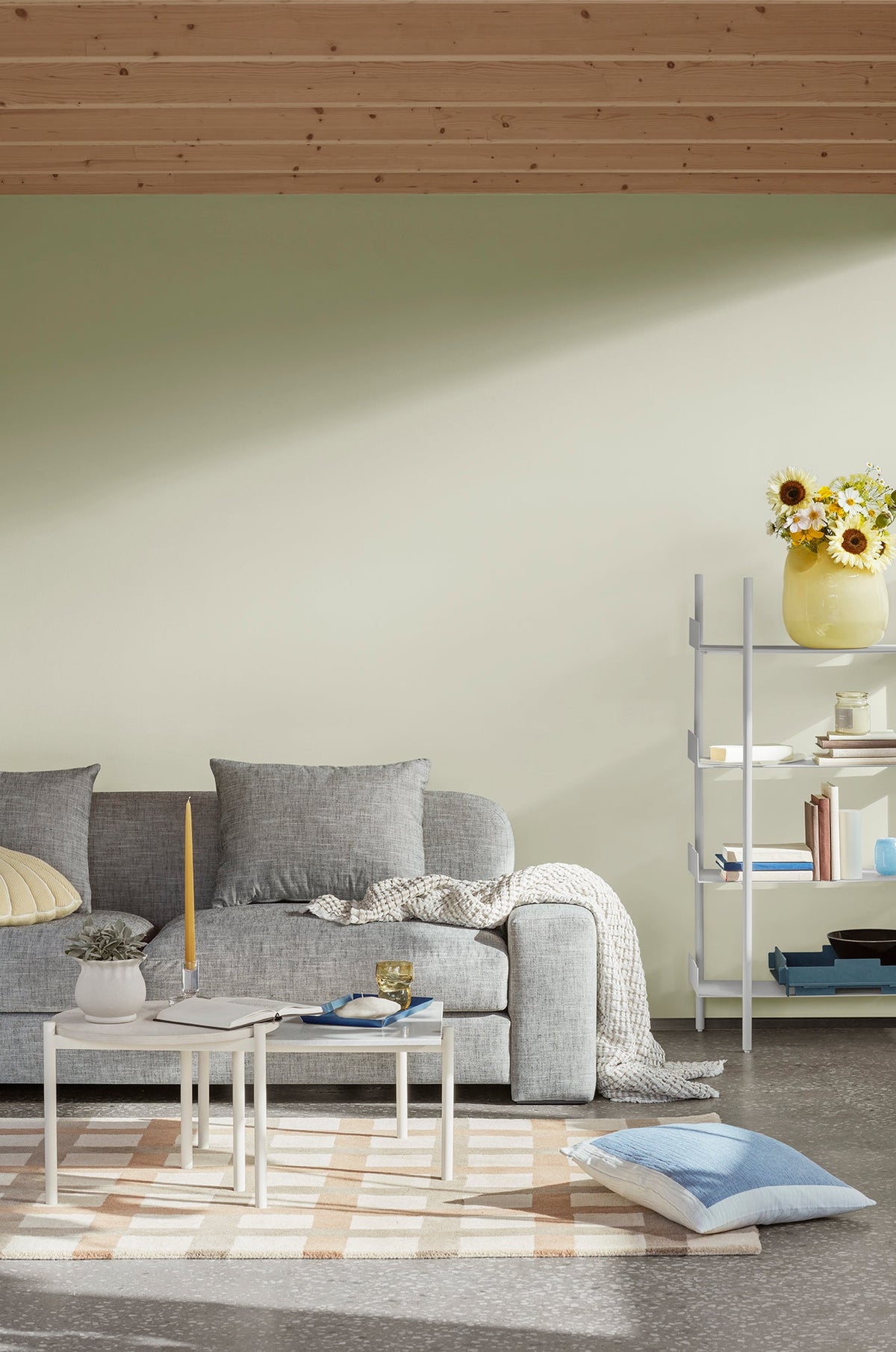 Light living room with a grey sofa and a taper candle on a low coffee table