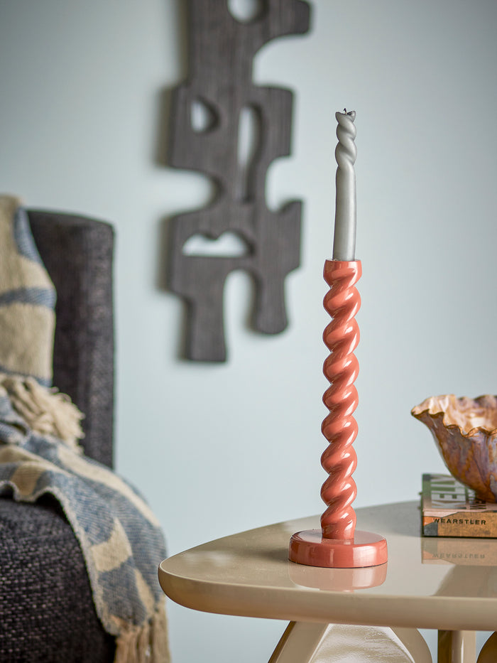 brown spiral diza candle holder with grey taper candle on side table
