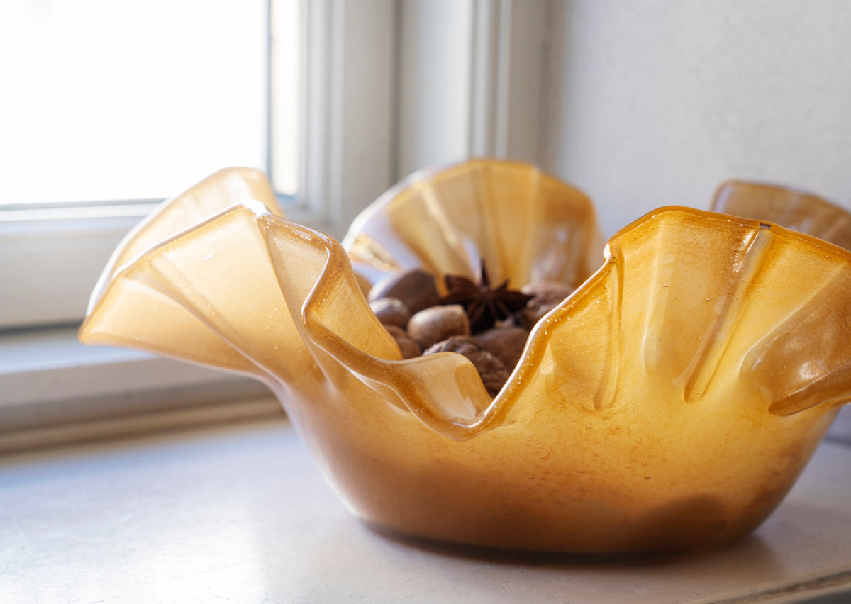 caramel ruffle glass bowl styled with decorative items in soft natural light