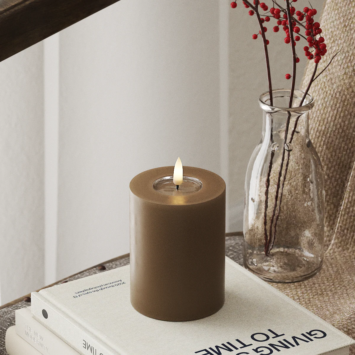 realistic large caramel LED candle glowing in a cosy winter home setting
