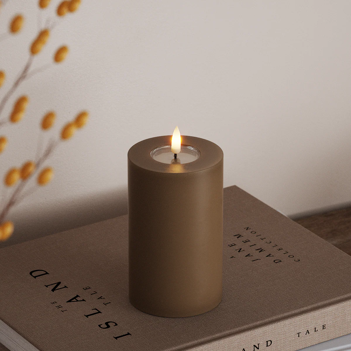 tall caramel LED candle with flickering flame styled beside autumn foliage on a tabletop
