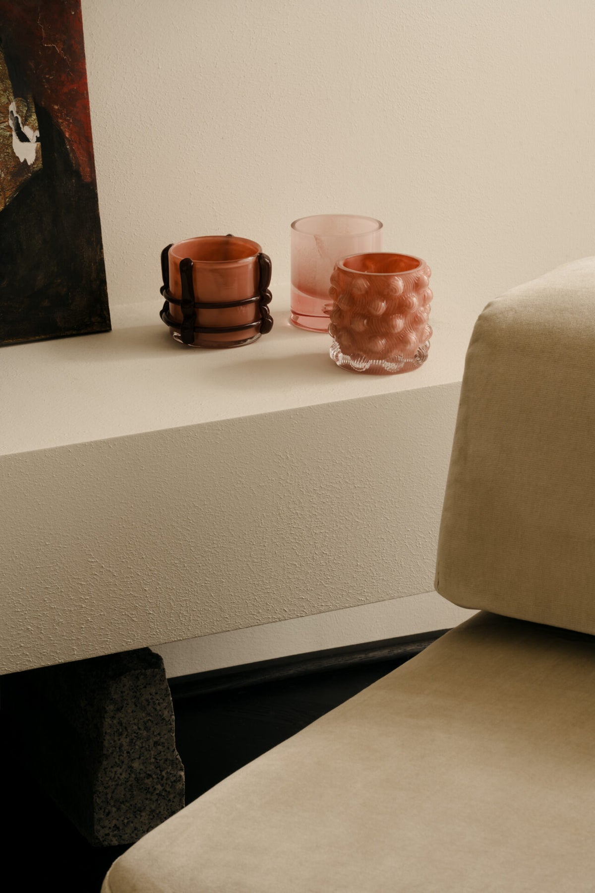 Caramel pink votive by Olsson & Jensen on a shelf beside a sofa