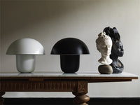 Carl-Johan mushroom table lamps by Olsson & Jensen in white and black styled on a wooden console