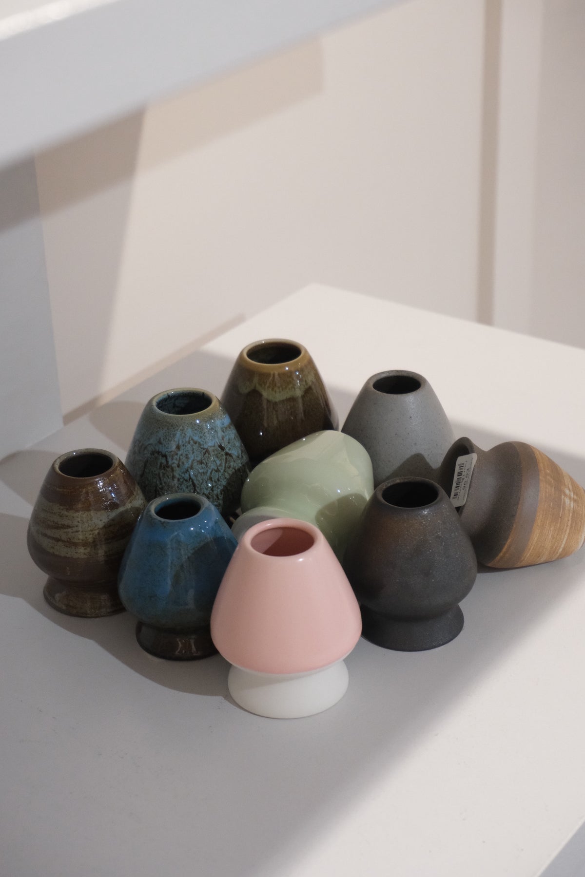 collection of ceramic chasen stands including pastel pink matcha whisk holder
