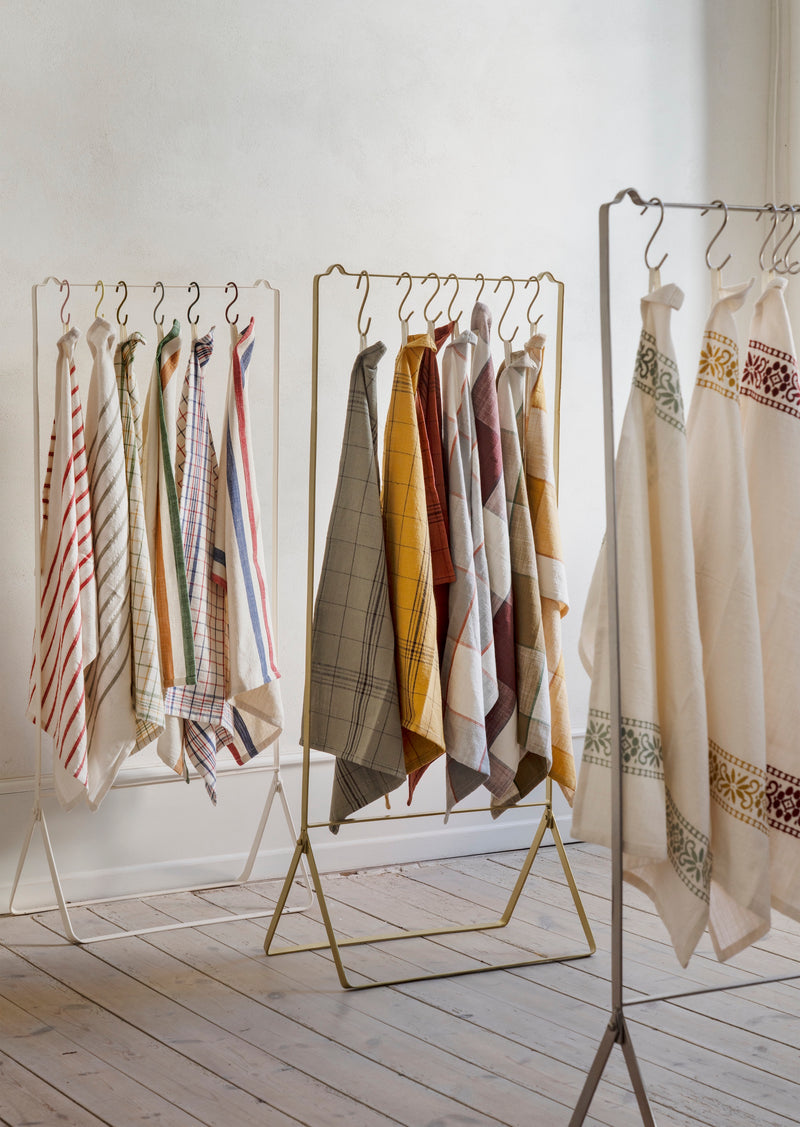 checked cotton kitchen towels in assorted colours hanging on display rack
