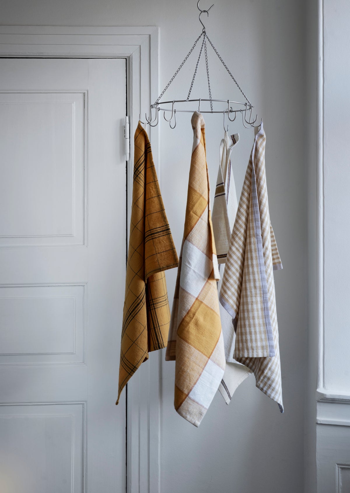 mustard and neutral checked kitchen towels hanging on metal rack
