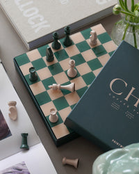 Chess set styled with books and flowers in modern interior