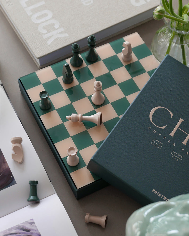 Chess set styled with books and flowers in modern interior