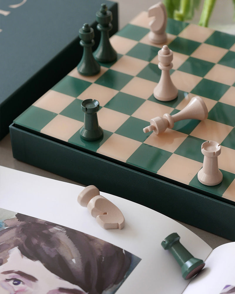 Green and cream chess board in play beside books