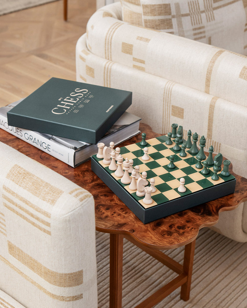 Angled view of wooden chess pieces on green acrylic board