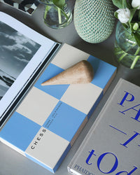 Blue and beige chess set styled with coffee table decor