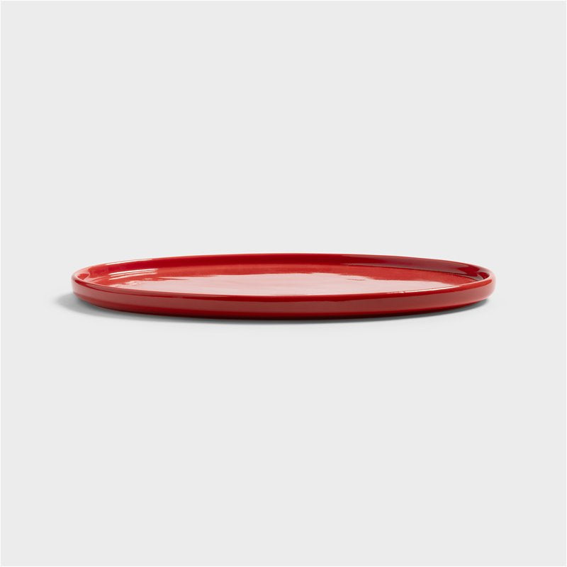 Side view of the slim red Chiquito porcelain tray with low rim
